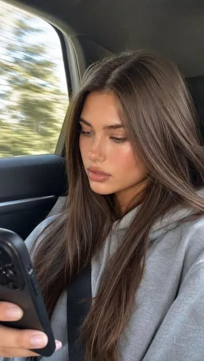 Realistic AI influencer in a car, captured in a casual phone-shot style